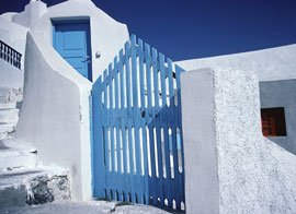 whitewashed villa with blue gate - santorini, greece